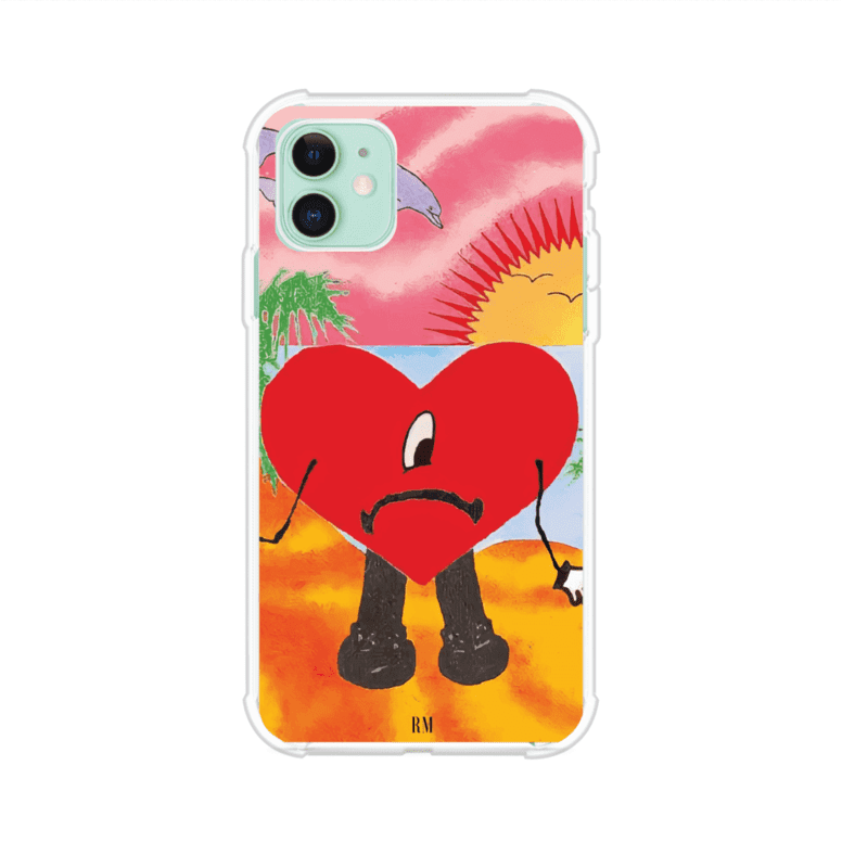 Funda para iPhone inspirada en el álbum "Un Verano Sin Ti" de Bad Bunny. Diseño con fondo de playa, palmeras, atardecer, delfines y el icónico corazón triste con piernas. Estilo colorido, urbano y veraniego. Producto de Remark Mx